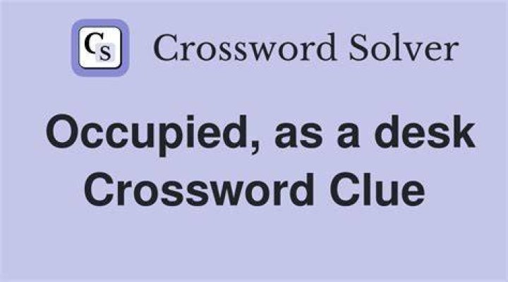 Occupy, as a desk Crossword Clue